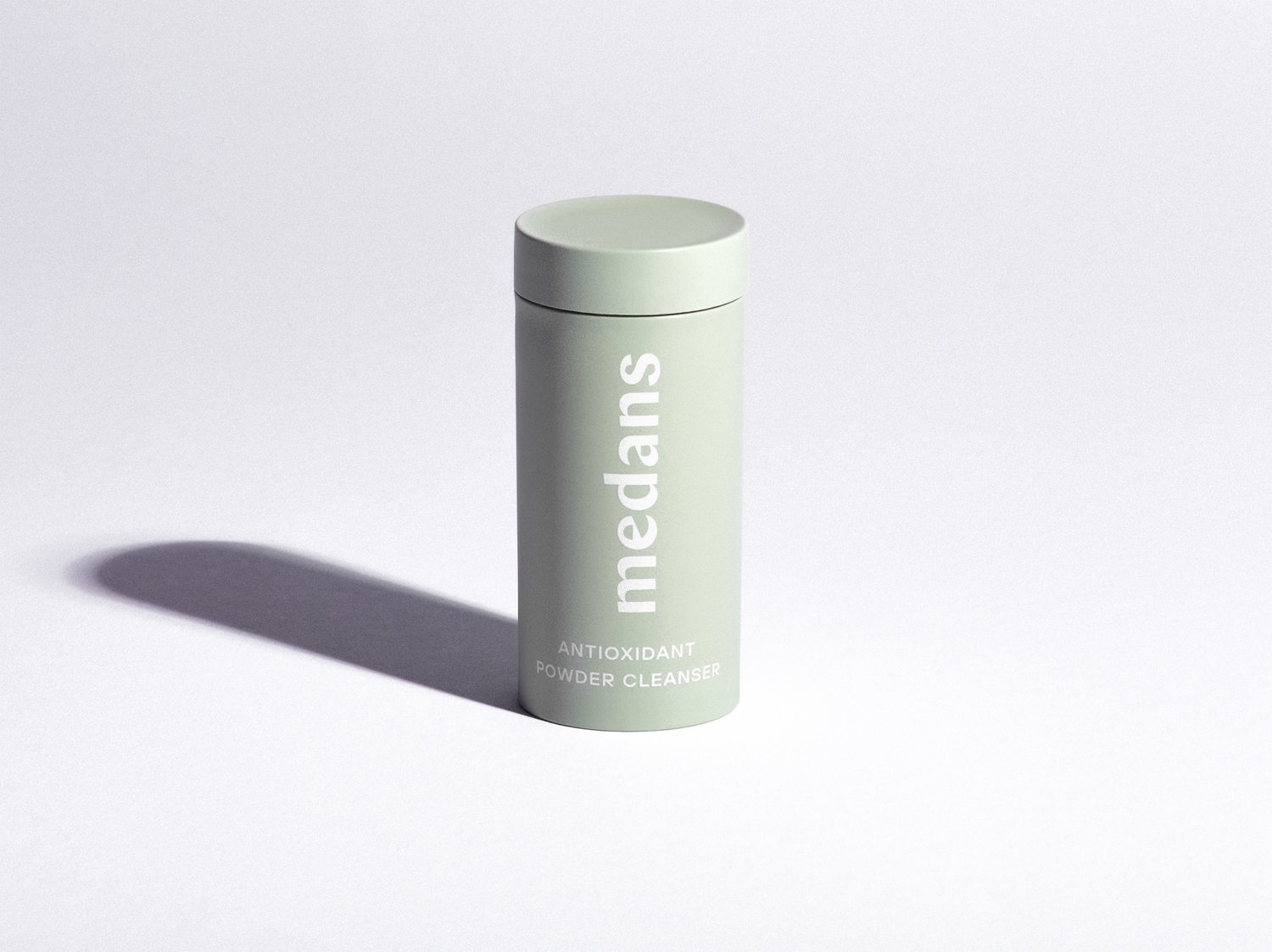 Green cylindrical medans container branding on a light gray background