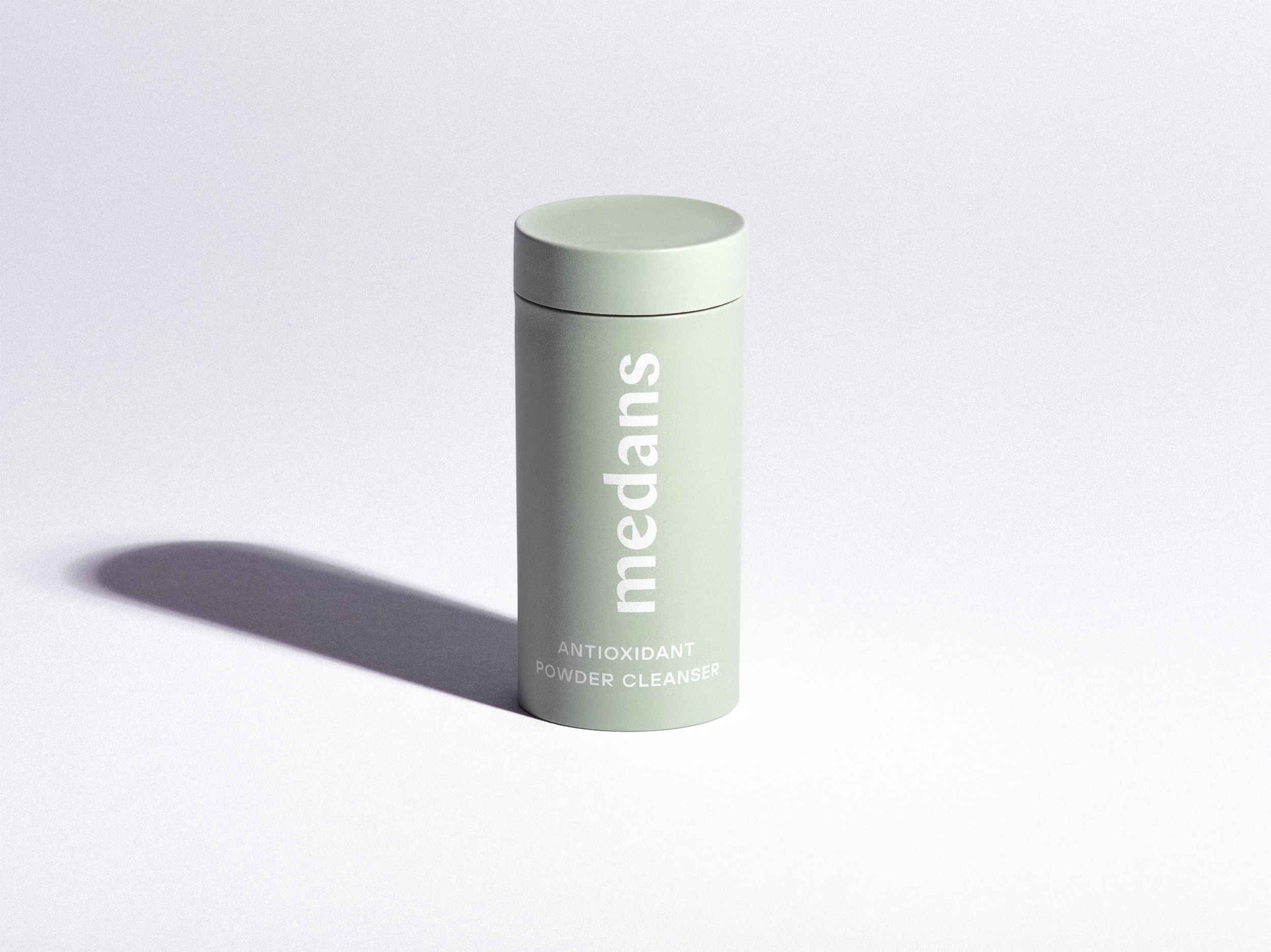 Green cylindrical medans container branding on a light gray background